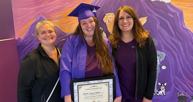 Christina in her cap and gown with her Licensed Veterinary Technician certificate